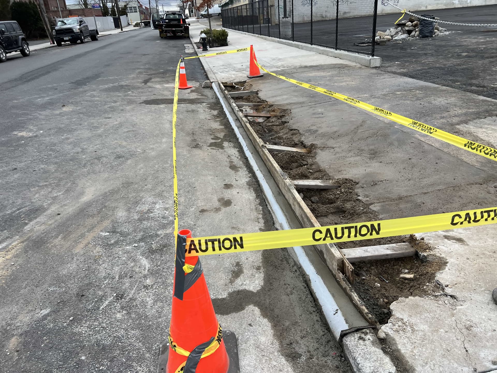 Curb replacement section secured with caution tape in NYC